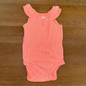 Carter's Peach Baby Onesie with White Floral Design.